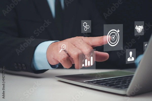 Fototapeta Businessman pointing finger at business target icon, Targeting the business concept, Business Growth and Vision, Business goal, Digital marketing, Set goals for better results, Marketing planning.