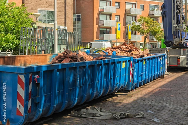 Obraz two long blue open industrial steel containers filled with roof tile waste