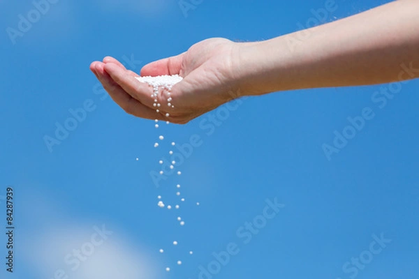 Fototapeta Hand full of small fertilizer