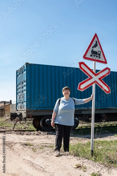 Obraz An elderly woman against the background of railway carriages.