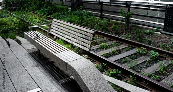 Fototapeta Bench on the high line park in Manhatten New York. A repurposed railway line is now visited by tourists and locals every day.