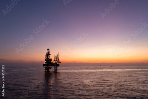 Obraz Aerial view of silhouette offshore jack up drilling rig during sunset - oil and gas industry.