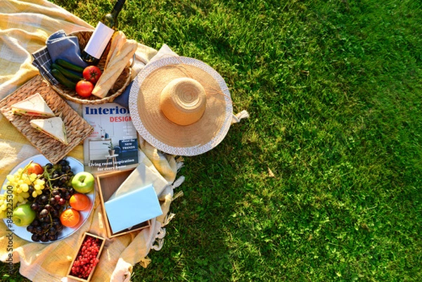Fototapeta Set for romantic picnic with tasty food and wine on green grass background beach