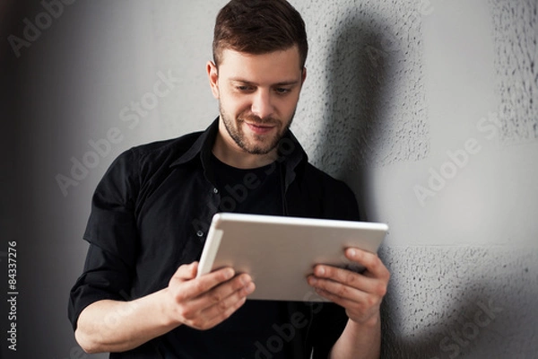Fototapeta Man with tablet by the wall