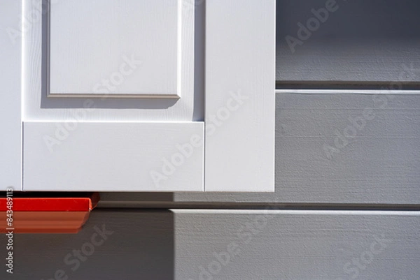 Fototapeta White shutters on a gray facade with red. High quality photo. Abstract minimalistic background