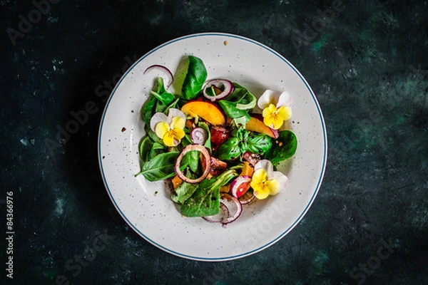 Fototapeta Coloful summer salad with nectarines and edible flowers. Top view.