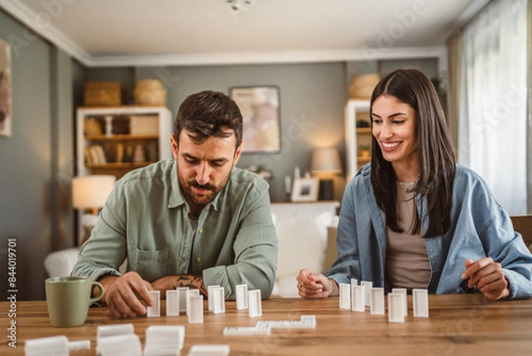 Obraz boyfriend and girlfriend play dominoes at home have fun together
