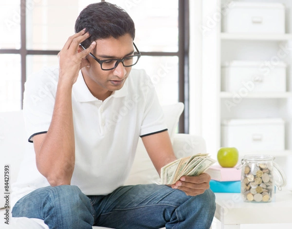 Obraz Stressed Indian guy counting money