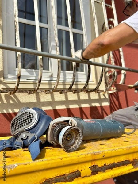 Fototapeta worker using a level, Working in a respirator, grinding metal with a machine
