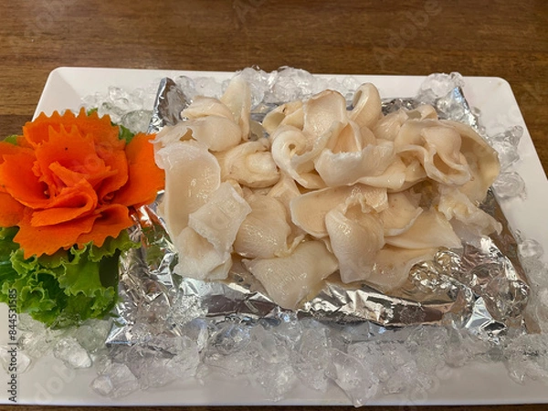 Fototapeta Thinly sliced ​​giant abalone served with seafood dipping sauce.