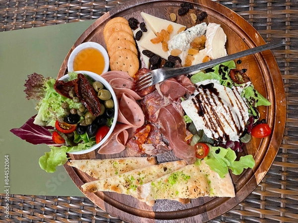 Fototapeta Cold cuts and Cheese board served with honey, crackers