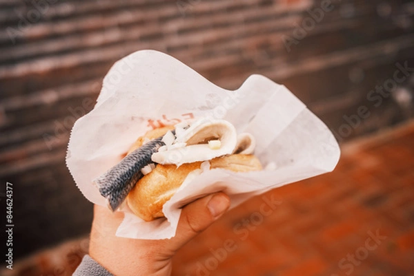 Fototapeta Fischbrötchen in einer Hand halten