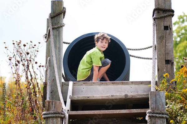 Obraz child about to go down a big tube slide at a rural playground