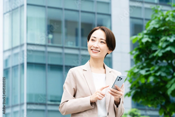 Obraz スマートフォンを操作している若い女性　ビジネスイメージ