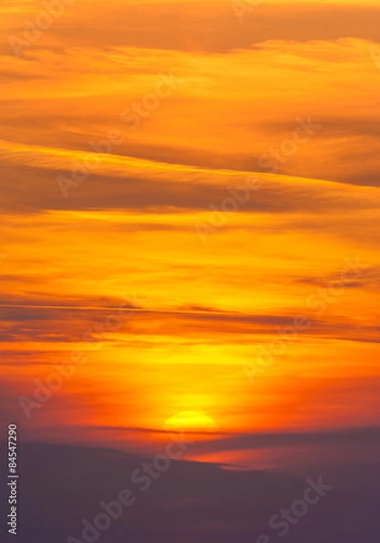 Fototapeta Jasny zachód słońca w ognistych chmurach cirrus - pionowe tło przyrody