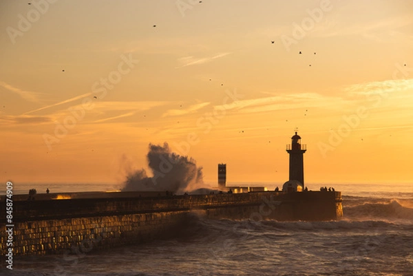 Fototapeta Sunset in the ocean by the lighthouse