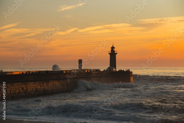 Fototapeta Sunset in the ocean by the lighthouse