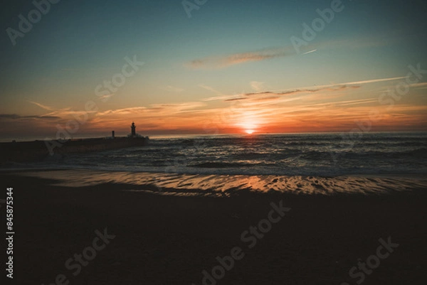 Fototapeta Sunset in the ocean by the lighthouse