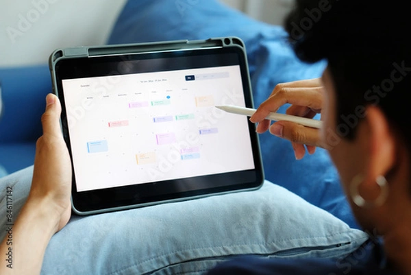 Fototapeta Man holding digital tablet with timeline project schedule, work plan mangement