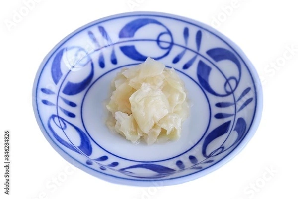 Fototapeta A close up shot of some pickled ginger on plate on white background.