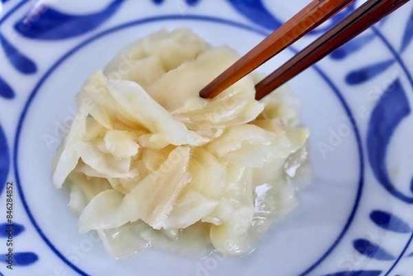 Fototapeta A close up shot of some pickled ginger with wooden chopsticks.