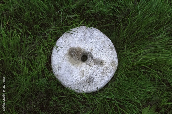 Obraz Old stone wheel on grass