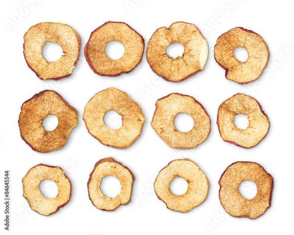 Obraz Dried apple rings sprinkled with cinnamon on white background.