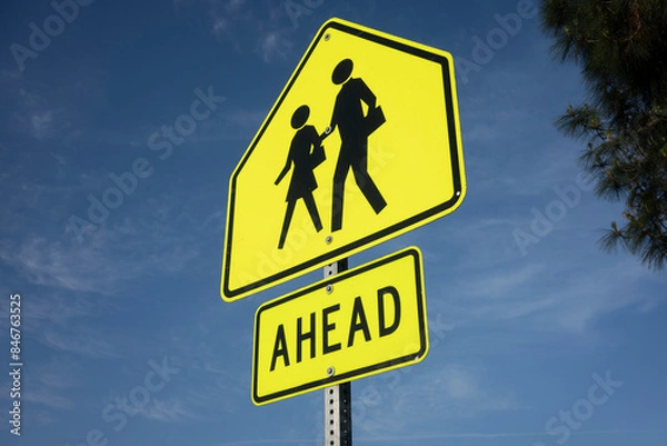 Obraz School crossing ahead signage against a blue sky background.