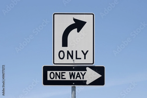 Obraz Right turn only and One Way road signs isolated against a blue sky background.