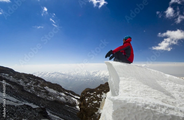Obraz man sitting on a snow cornice in mountain sunrise