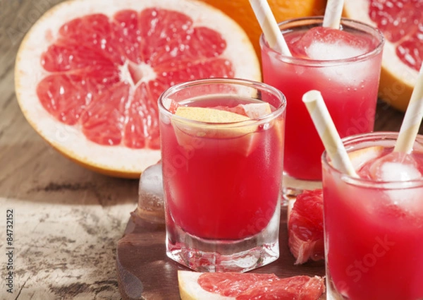 Fototapeta Pink grapefruit drink with pulp, selective focus