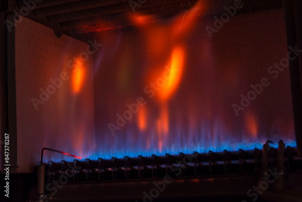 Fototapeta Combustión en el interior de una caldera de gas. Un quemador calienta un intercambiador de calor de cobre.
