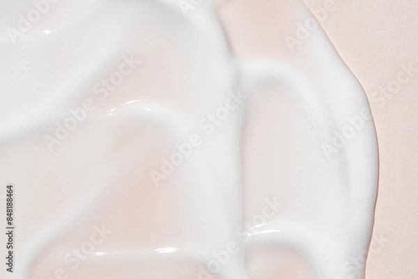 Fototapeta Texture of white cream on pink background. Smear of moisturizer close up. Lotion swatch. Beauty skin care product smear smudge. SPF sunscreen cream sample on pink background