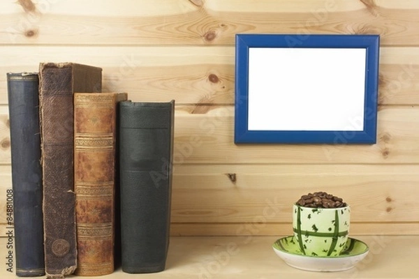 Fototapeta wooden shelf with old books and picture frame for your text.
