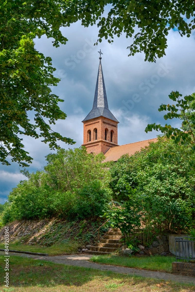 Fototapeta Auf einer Anhöhe erhebt sich die denkmalgeschützte Dorfkirche Emstal mit ihrem hoch aufragenden Westturm (Ansicht von Südosten)