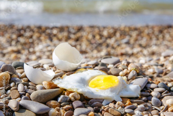 Obraz A chicken egg was fried in the sand. Hot weather on the beach.