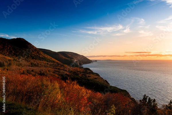 Fototapeta Scenic view of the coastline with the sea and mountains at the Cape Breton Highlands National Park, in Nova Scotia, Canada, at sunset.