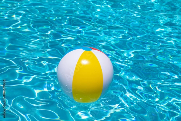 Obraz Beach ball floating in swimming pool. Advertising for summer vacations. Space for text. Colorful beach ball in swimming pool.