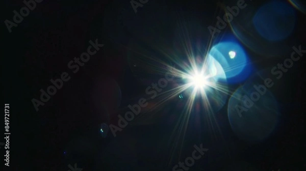 Fototapeta A bright light shining on a dark background, lens flare effects for overlay designs