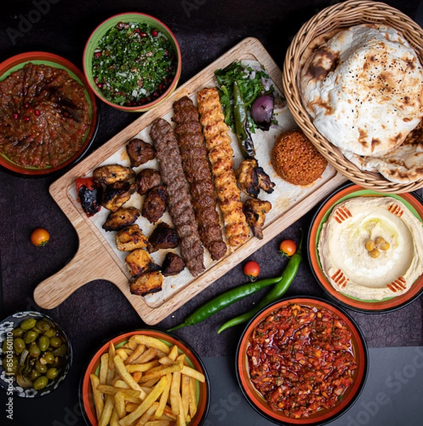 Fototapeta Arabic grilled arabic food dishes kebab, dolma, mansaf, shawarma Turkish and Arabic Traditional Ramadan Mix Vali Kebab Plate inside Adana, Urfa, Chicken, Lamb, Liver and Beef on bread on table