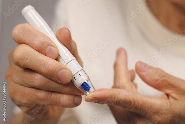 Fototapeta 혈당 측정을 하고 있는 여성 어르신의 손 클로즈업. 당뇨병 관리 개념