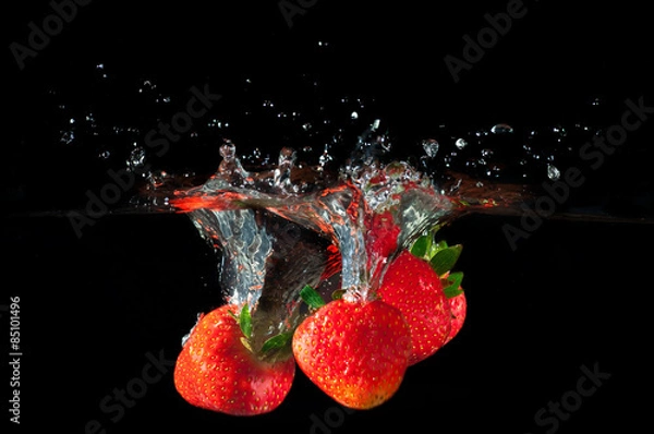 Obraz Strawberries splashing into water