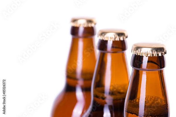 Fototapeta Three bottles of ice cold beer isolated on white