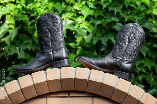 Obraz Men cowboy boots stand on stone arch..