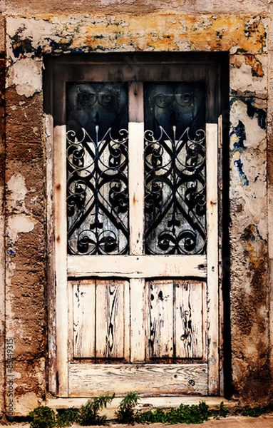 Fototapeta An old and worse-for-wear wooden door with wrought iron decorative windows