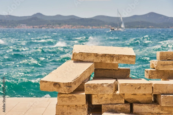 Obraz Old granite tiles for laying a sidewalk with the sea in the background.