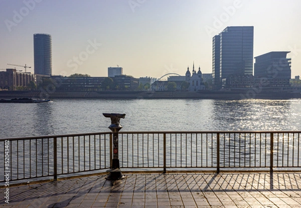 Fototapeta Rhine River skyline with viewing binoculars and the district of Deutz in Cologne, Germany