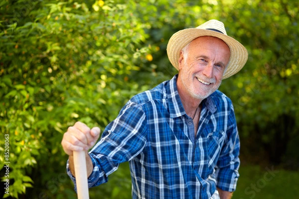 Obraz Senior man in garden with straw hat