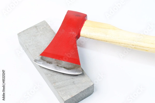 Obraz Stone sharpening an ax on a white background.