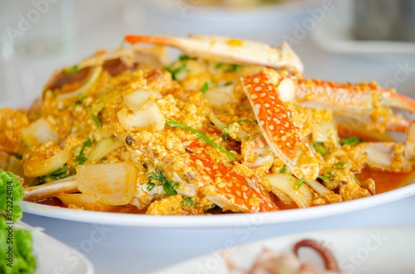 Fototapeta Blue Crab in Curry Powder  is a vibrant Thai dish with tender crab in a creamy, aromatic yellow curry sauce, mixed with bell peppers and onions. A visually appealing and flavorful seafood delight.